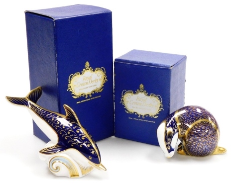 A Royal Crown Derby porcelain Dolphin paperweight, gold stopper, 17cm wide, and a badger paperweight, gold stopper, 8cm high, both boxed.