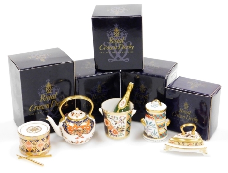 A group of Royal Crown Derby porcelain miniature items, comprising toy drum, 4cm high, miniature champagne bucket and bottle, miniature iron, miniature kettle and tree of life miniature churn. (5)