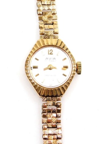 An Avia 9ct gold lady's wristwatch, with small silvered dial, in a fan design outer case, on five bar design bark effect bracelet, 19cm long, 14.2g all in.