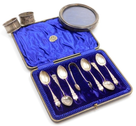 A group of small silver, to include a set of six Edward VII silver teaspoons and sugar tongs, Birmingham 1902, in an associated fitted case, two napkin rings, and a circular silver mounded photograph frame, Sheffield 1901, 11.5cm diameter, weighable silve