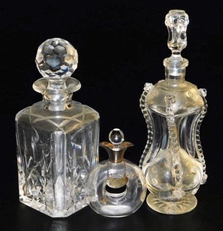 A square cut glass whisky decanter, 25cm high, a Venetian glass decanter and stopper, of hour glass form, 29cm high, and a small whisky glass with silver collar and decanter label, the bottle bearing inscription "When sinking' take hold", Birmingham 1912,