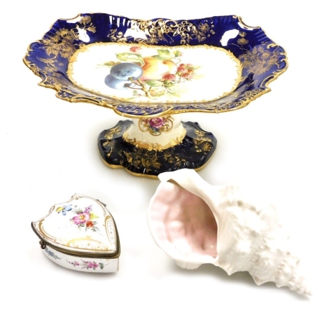 A Hammersley & Co porcelain dessert comport, decorated with fruit, within a blue gilt highlighted border, 12cm high, a Branksone China conch shell, and a German porcelain shield shaped dressing table box and cover, decorated with flowers, gilt highlights,