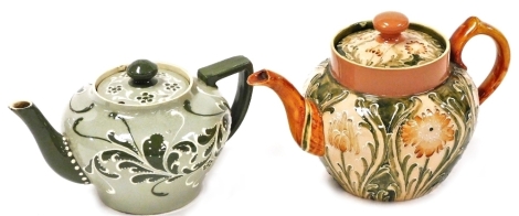 A Moorcroft Macintyre and Co Florian ware bachelor's teapot and cover, of bullet shaped form, decorated with flowers against a green and peach ground, lid stapled, printed marks, 10.5cm high, and a Macintyre and Co Esso Faience bachelor's teapot and cover