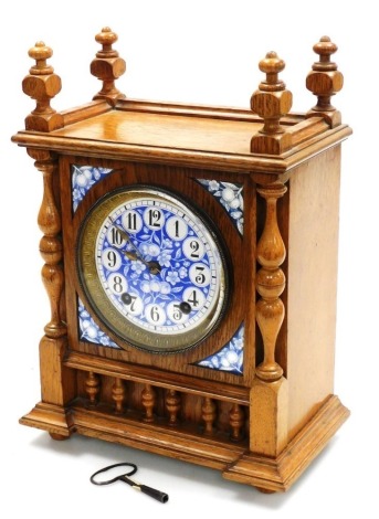 A late 19thC German oak cased mantel clock, the circular blue and white enamel dial decorated with fruit and blossom, bearing Arabic numerals, similarly decorated spandrels, eight day movement by Winterhalder & Hofmeier, with coil strike, the case of rect