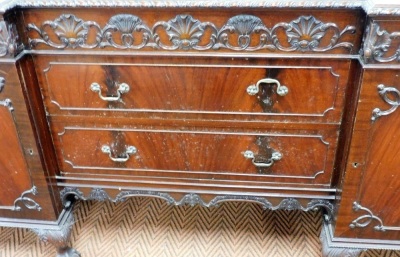 An early 20thC Adam style mahogany breakfront sideboard, with one long and two short fitted cushion drawers, carved with repeating scallop shells, Prince of Wales feathers and foliate scrolls, over two long drawers flanked by a pair of cupboard doors, the - 2