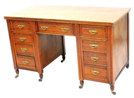 A Victorian mahogany twin pedestal desk, with one long drawer flanked by eight short drawers, raised on turned legs brass capped on castors, 73cm high, 122cm wide, 57cm deep.