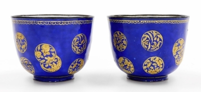 A pair of 19thC Chinese Canton enamel wine cups, decorated with overlapping gilt roundels on a blue ground, 6cm high. - 2