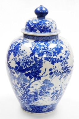 A Japanese Meiji period Seto blue and white porcelain vase and cover, of ovoid form, profusely decorated trees, flowers and blossom, within geometric and scroll banding, 56cm high. (AF) - 2