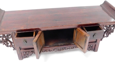 A Chinese stained wood writing table, carved with scrolling prunus blossom fret work, having a pair of central doors, flanked by two small drawers, 34cm high, 92cm wide, 17.5cm deep. - 3