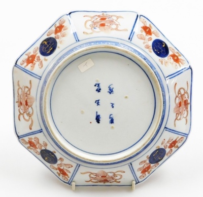 A pair of Japanese Meiji period Imari porcelain dishes, of octagonal form, decorated centrally in blue and white with scrolling leaves, the ground and border reserves decorated with peonies and Buddhist emblems, six character Chinese mark "Qi Yu bao ding - 7