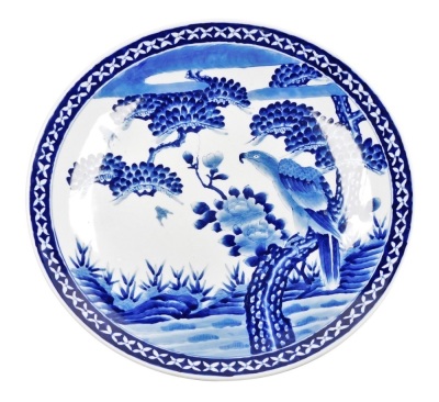 A Japanese blue and white porcelain charger, depicting a hawk and flowering branch, 46cm diameter.