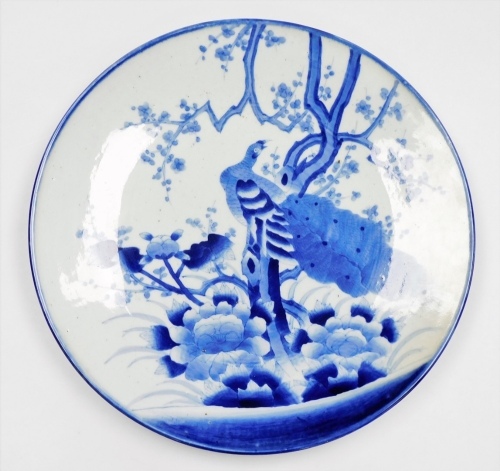 A Japanese blue and white charger, depicting peacock and flowering tree branch, 46cm diameter.