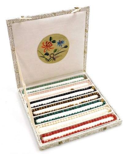 A set of seven gemstone beaded necklaces, comprising carnelian, malachite, rose quartz, eventurine, tigers eye, white peking jade, and black onyx, contained in a presentation box, each necklace 42cm long.