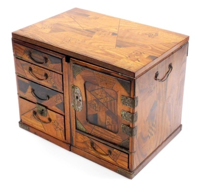 A Japanese Meiji period metamorphic parquetry travelling writing desk, comprising two cabinets with seven drawers and carrying handles, the removable top forming the writing surface when assembled, dimensions (when closed) 25cm high, 32.5cm wide, 22cm dee