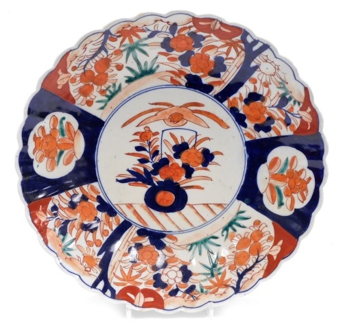 A Japanese Meiji period Imari charger, of fluted form, the centre decorated with vase and flowers surrounded by reserves of flowers, 30cm diameter.