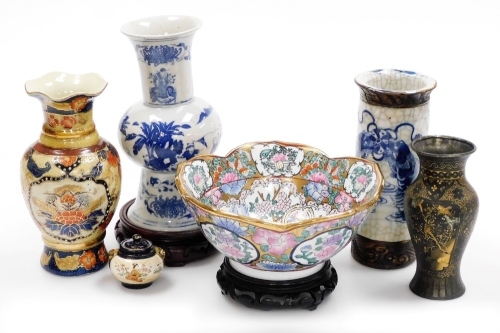 A group of Oriental wares, to include a blue and white vase with six character mark to underside, 22cm high, bowl with gilt highlights, 20cm diameter, metal baluster vase with gilt highlights, five character mark to underside, 14cm high, two hardwood base