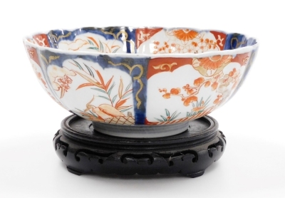 A 19thC Japanese Imari bowl, of fluted form, 25cm diameter, on hardwood stand. - 2