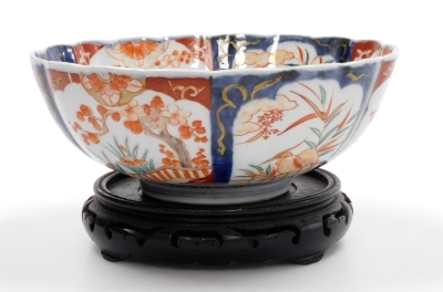 A 19thC Japanese Imari bowl, of fluted form, 25cm diameter, on hardwood stand. - 4
