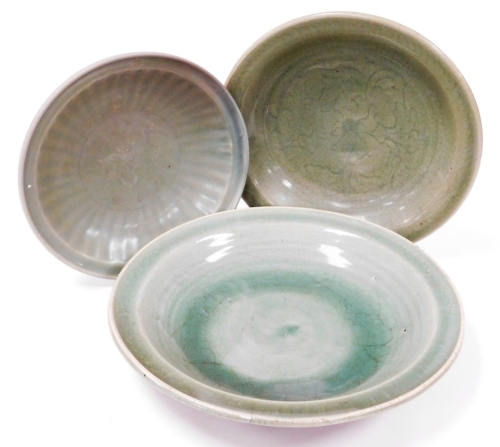 Three graduated celadon dishes, two with incised or moulded decoration, 38cm, 30cm and 27cm. (3)