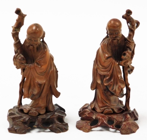 Two 19thC Chinese carved hardwood figures of sages, each holding a gnarled staff, 15cm high.