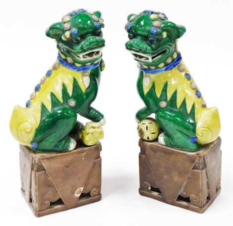 A pair of early 20thC Chinese porcelain dogs of fo, each glazed in green, blue, brown and yellow, 34cm high. (AF)