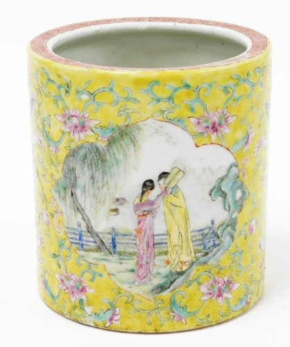 A 19thC Chinese porcelain famille jaune brush pot, with scrolling floral ground containing two shaped cartouches with enamel decoration of figures and landscape, 14cm high, 13cm diameter.