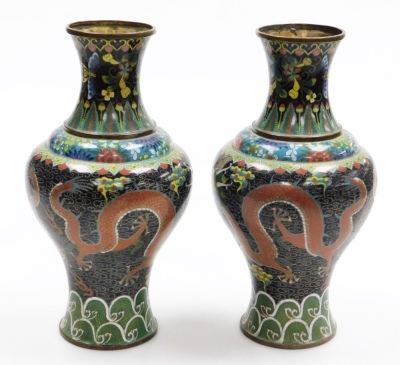 A pair of late 19thC Chinese cloisonne enamel vases, with brass rims, decorated with Imperial dragons in the clouds chasing a flaming pearl, on a black ground, within floral and acanthus leaf borders, 32.5cm high. - 2