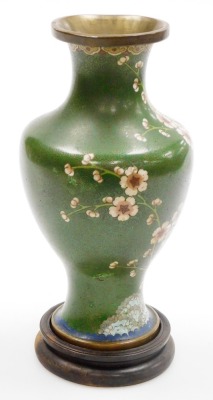 A Chinese cloisonne enamel vase, with brass rims, of baluster form, decorated with prunus blossom on a green ground, 22.5cm high, on a hardwood stand. (AF) - 4