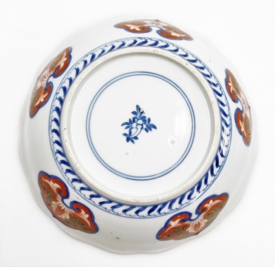 A Japanese Kenjo style Imari porcelain bowl, painted with reserves of flowers, and scrolling leaves, blue printed flower mark, 18.5cm diameter, on a hardwood stand. - 3