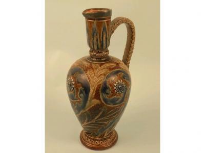A Doulton Lambeth stoneware ewer decorated with foliate scrolls and flowerheads