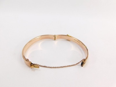 A 9ct rose gold hinged bangle, the half hinged design with hatched detail and buckle, 6cm wide, with safety chain, 16.7g all in, boxed. - 2