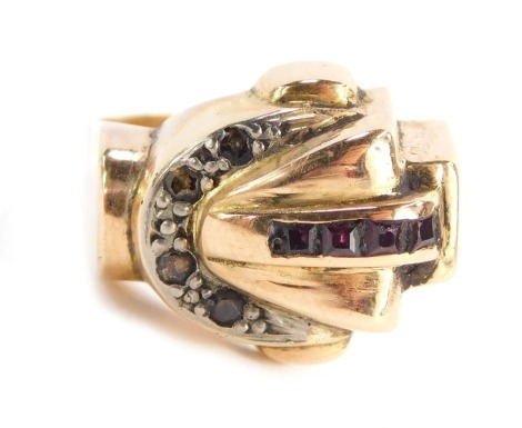 A dress ring with buckle top, set with rubies and diamond stones, in white and yellow gold, stamped 18k, size P 1/2, 7.4g all in.