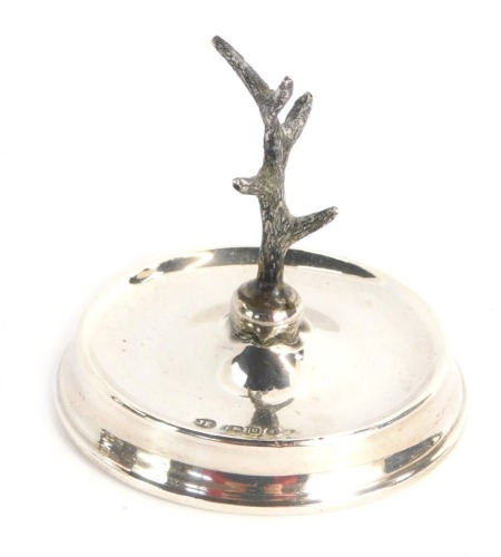 A George V silver ring stand, with well and antelope centre, London 1922, weighted base, 2½oz gross.