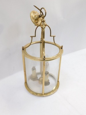 A brass lantern, with an arched top and three fittings and four glass sections, 56cm high before hanging. - 2