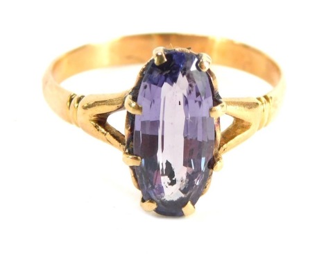 An amethyst dress ring, with oval amethyst in eight claw setting with V splayed rib design shoulders, yellow metal stamped 750, size O, 2.6g all in.