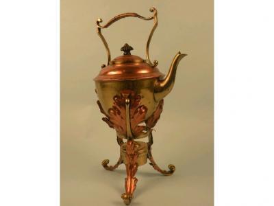 An Arts & Crafts style copper and brass tea kettle and stand decorated with leaves