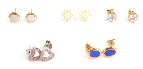 Five pairs of 9ct gold and other earrings, comprising a pair of 9ct gold and opal studs, a pair of 9ct gold and fire opal studs, a pair of 9ct gold and paste stone set studs, silver heart studs and a further cluster pair unmarked, 7.3g all in. (5)