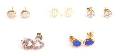 Five pairs of 9ct gold and other earrings, comprising a pair of 9ct gold and opal studs, a pair of 9ct gold and fire opal studs, a pair of 9ct gold and paste stone set studs, silver heart studs and a further cluster pair unmarked, 7.3g all in. (5)