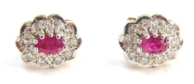 A pair of ruby and diamond cluster earrings, each with central oval cut ruby, surrounded by tiny diamond in pave type setting, rose basket, yellow metal back, unmarked believed to be 9ct, 1.8g all in, contained in Dryden & Son of Spalding jewellery box.