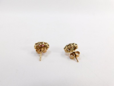 A pair of ruby and diamond cluster earrings, each with central oval cut ruby, surrounded by tiny diamond in pave type setting, rose basket, yellow metal back, unmarked believed to be 9ct, 1.8g all in, contained in Dryden & Son of Spalding jewellery box. - 2