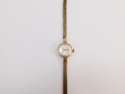 A Garrard 9ct lady's wristwatch, with small silvered dial, bearing inscription to reverse, Jaguar Daimler Cars Coventry Presented to Mrs R M Close 1952 - 1975, the dial 1.5cm wide, on brickette effect bracelet, 19cm long, 16.2g all in, boxed. - 2