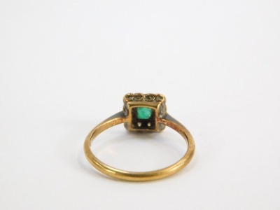 An emerald and diamond cluster ring, the square set panel with square cut emerald in rub over setting, surrounded by diamonds on a thin band, yellow metal stamped 18ct plat., ring size L, 2.3g all in. - 2