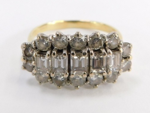 A diamond cluster ring, the panel set with five square cut diamonds, surrounded by round brilliant cut diamonds, totalling approx 0.98cts overall, in a raised basket setting, yellow metal stamped 18, ring size M, 4g all in.