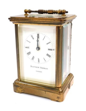 A Matthew Norman of London carriage clock, in brass casing with white enamel dial, in a presentation book case, 11cm high and 6cm deep.