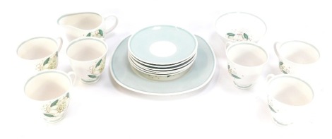 A Wedgwood Susie Cooper part tea service, on turquoise ground with painted flower, comprising six cups and saucers, cake plate, milk jug, and sugar bowl.