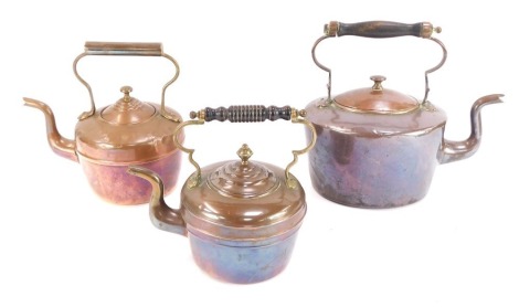 Three Victorian copper kettles, two with ebony handles, the largest 29cm high, smallest 22cm high.