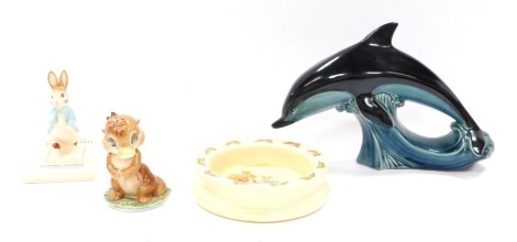 A Poole Pottery dolphin, a David Hand Animaland Dinkum Platypus figure, John Beswick Tale of Peter Rabbit Peter on his book figure, and a Bunnykins child's bowl. (4)