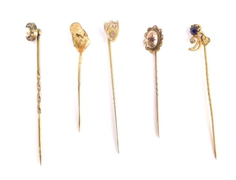 Five stick pins, comprising a shield crested top pin, golden nugget design pin, various others, three stamped 9ct, others unmarked, 6g all in. (5)