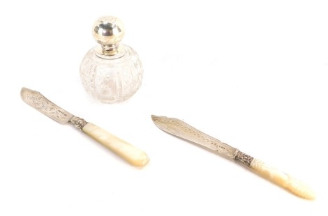 Silver items, comprising a silver topped and cut glass dressing table jar and two mother of pearl handled and silver collared and laded fish knives. (3)