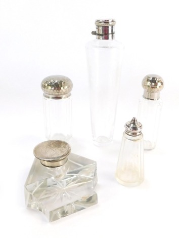 A cut glass and silver lidded inkwell, silver capped hip flask, and two dressing table jars with hammered tops and a pepper pot, each with a silver top or collar . (5)